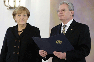 El presidente alemán, Joachim Gauck (dcha), entrega las credenciales a la reelegida canciller alemana, Angela Merkel 